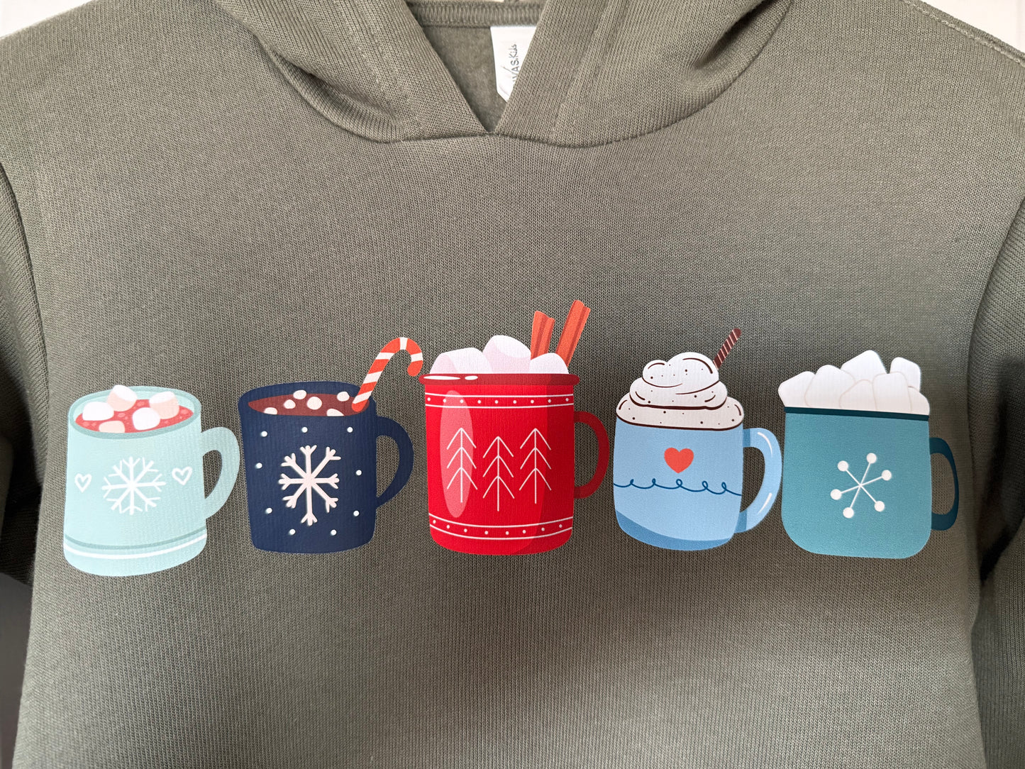 Green hoodie with colorful hot chocolate mugs design on a plain background