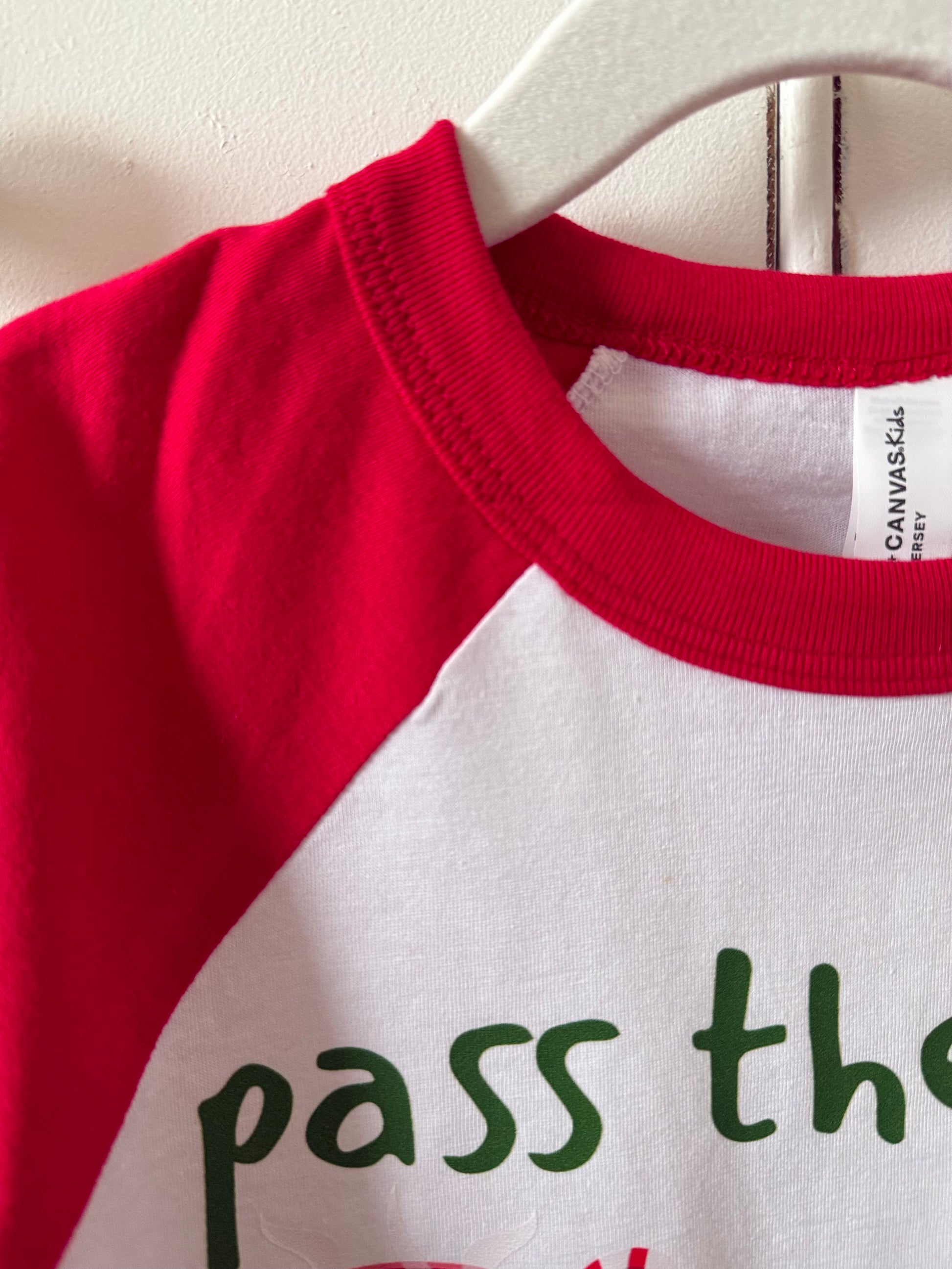 Red and white shirt with text on a hanger
