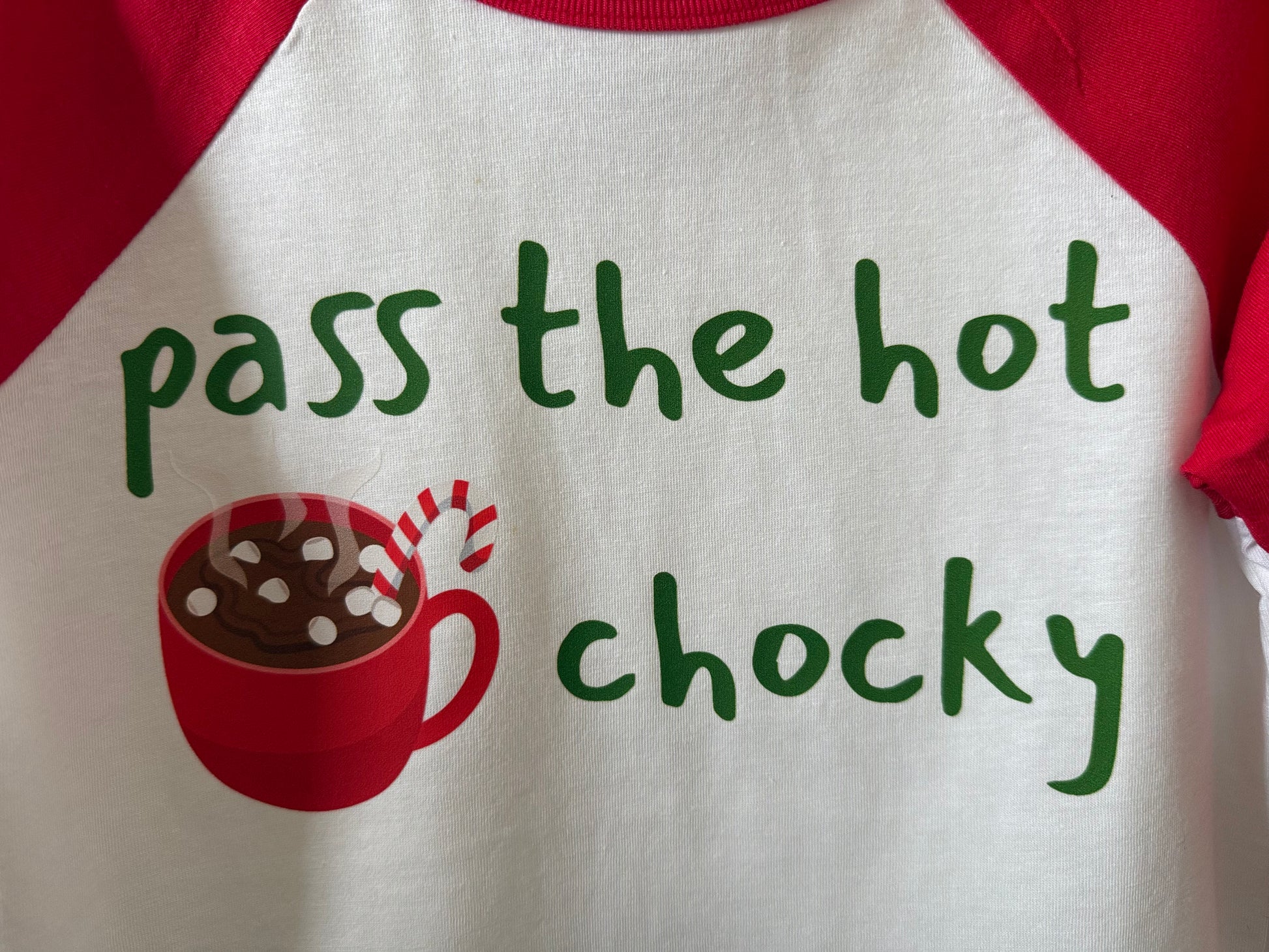 Red and white shirt with hot chocolate graphic and text 'pass the hot chochy' on a white background