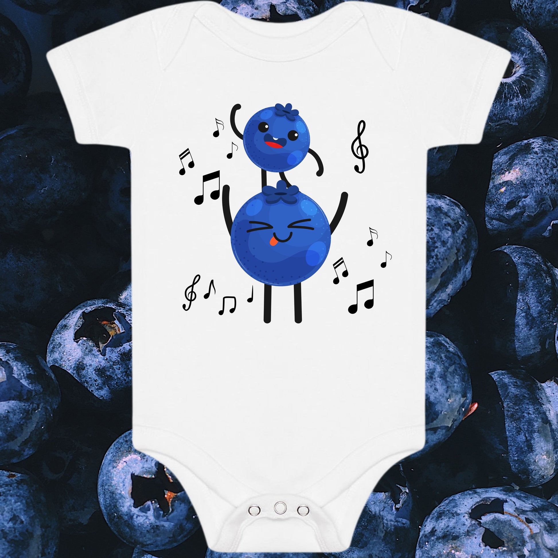 White baby onesie with blueberry character design on a background of blueberries