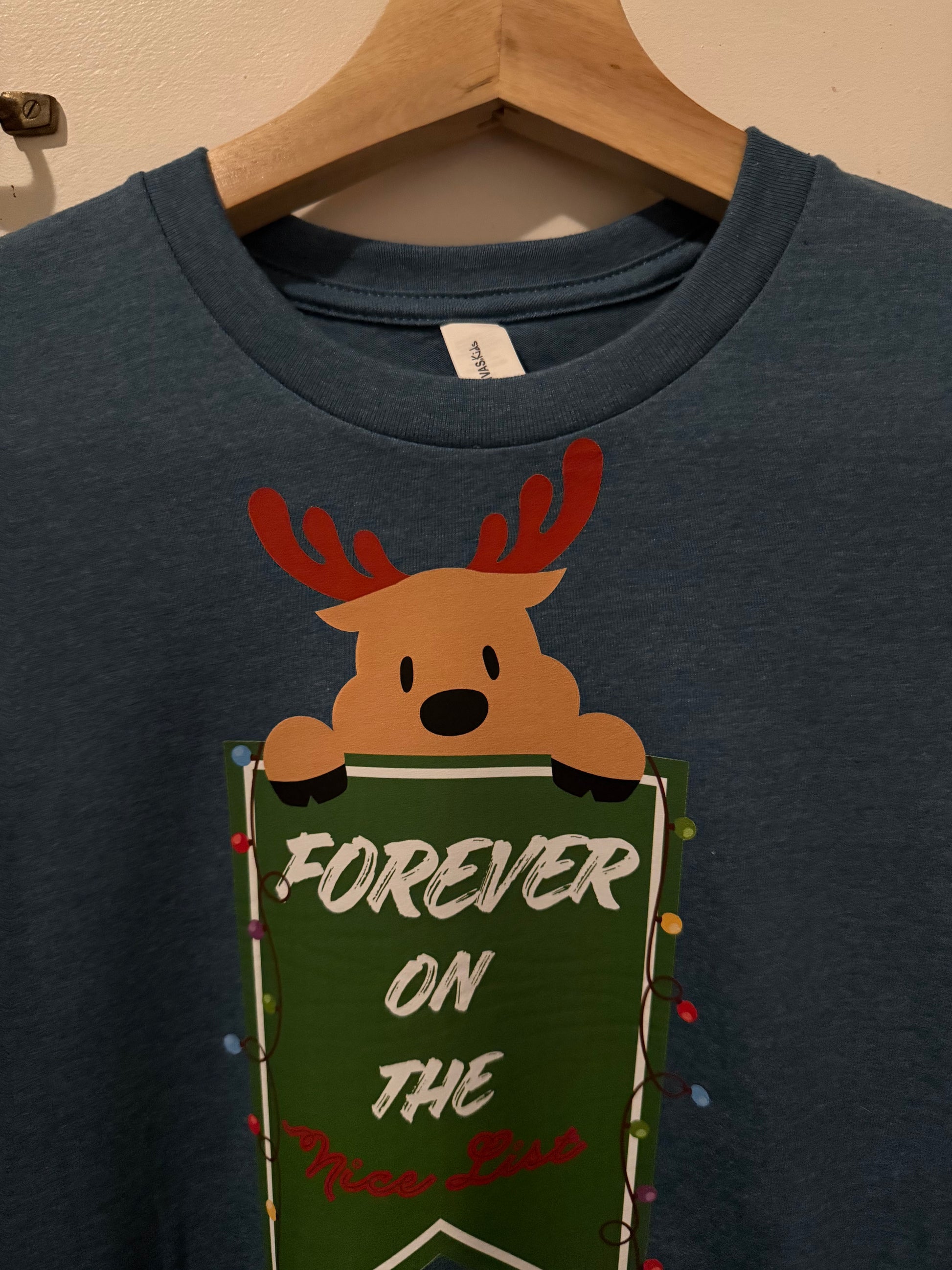 Navy blue t-shirt with a reindeer and book graphic on a beige background
