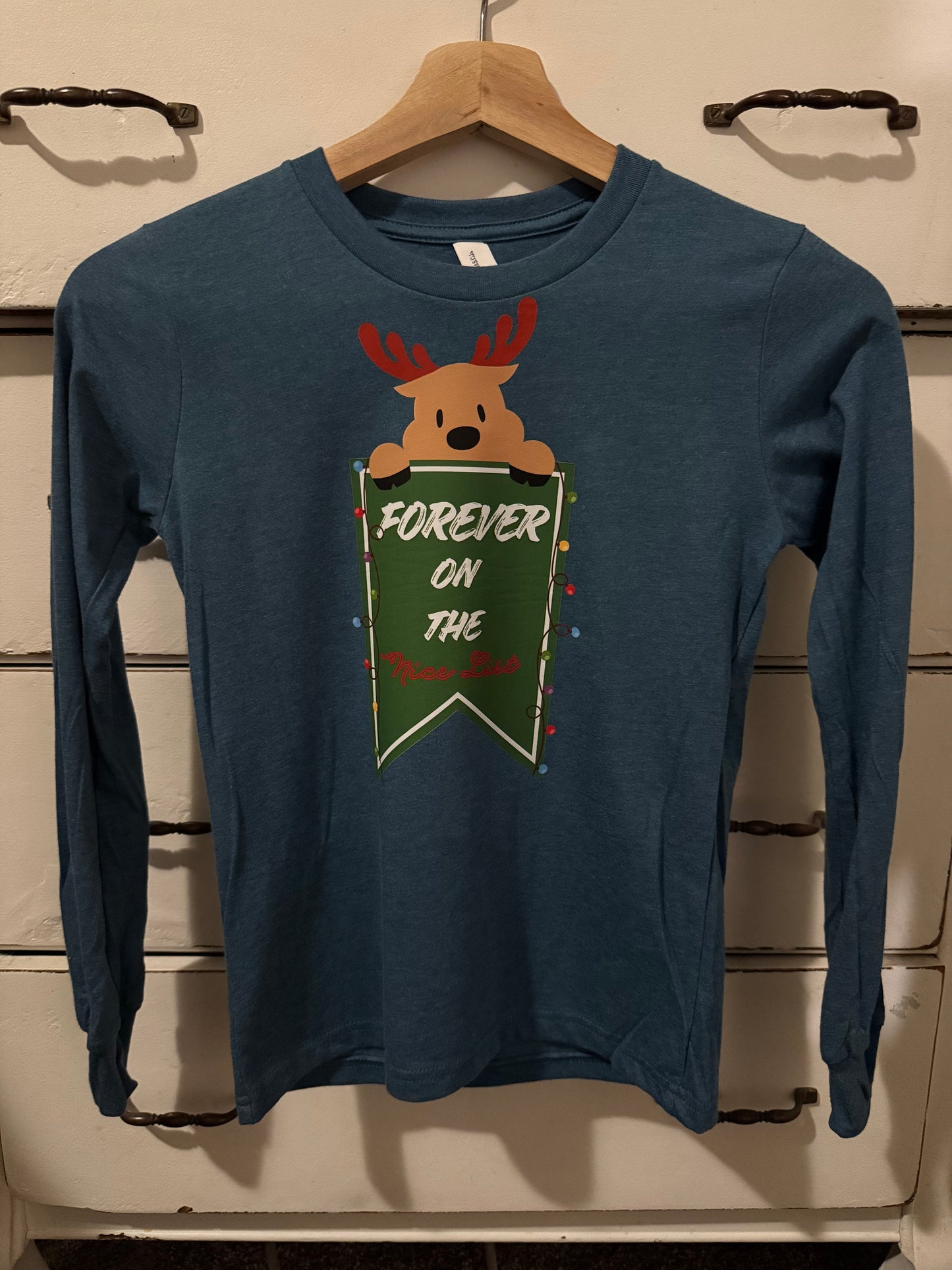 Navy blue sweatshirt with reindeer graphic on a wooden surface