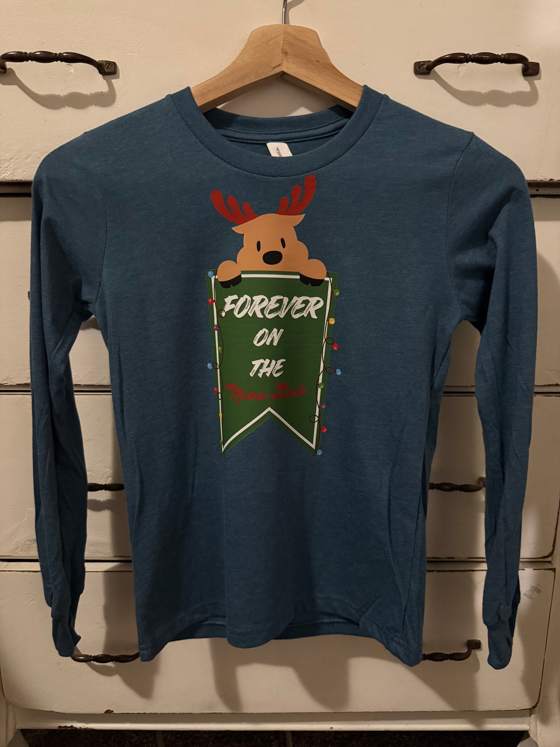 Navy blue sweatshirt with reindeer graphic on a wooden surface