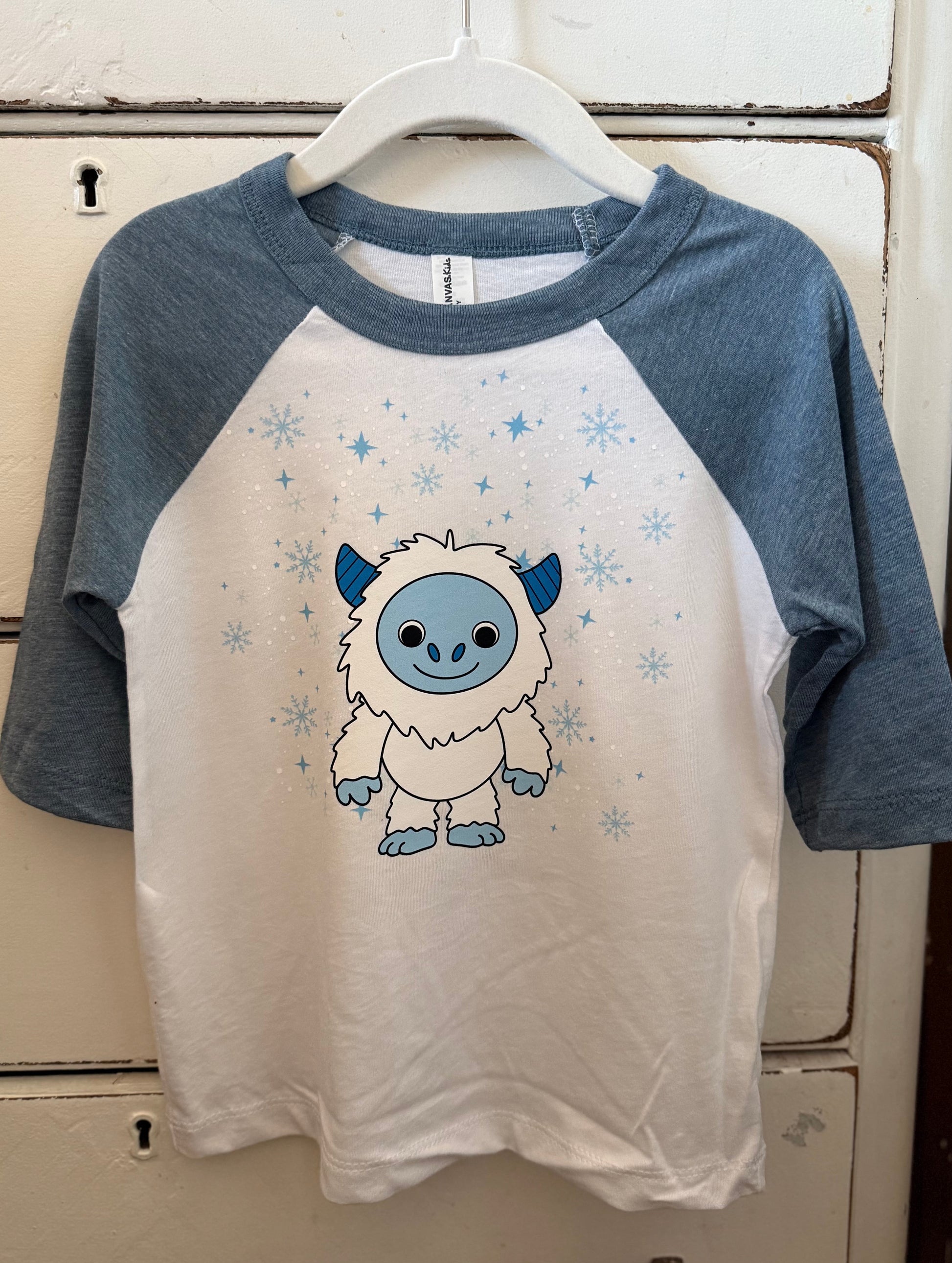 Children's t-shirt with a cartoon character on a hanger against a white background