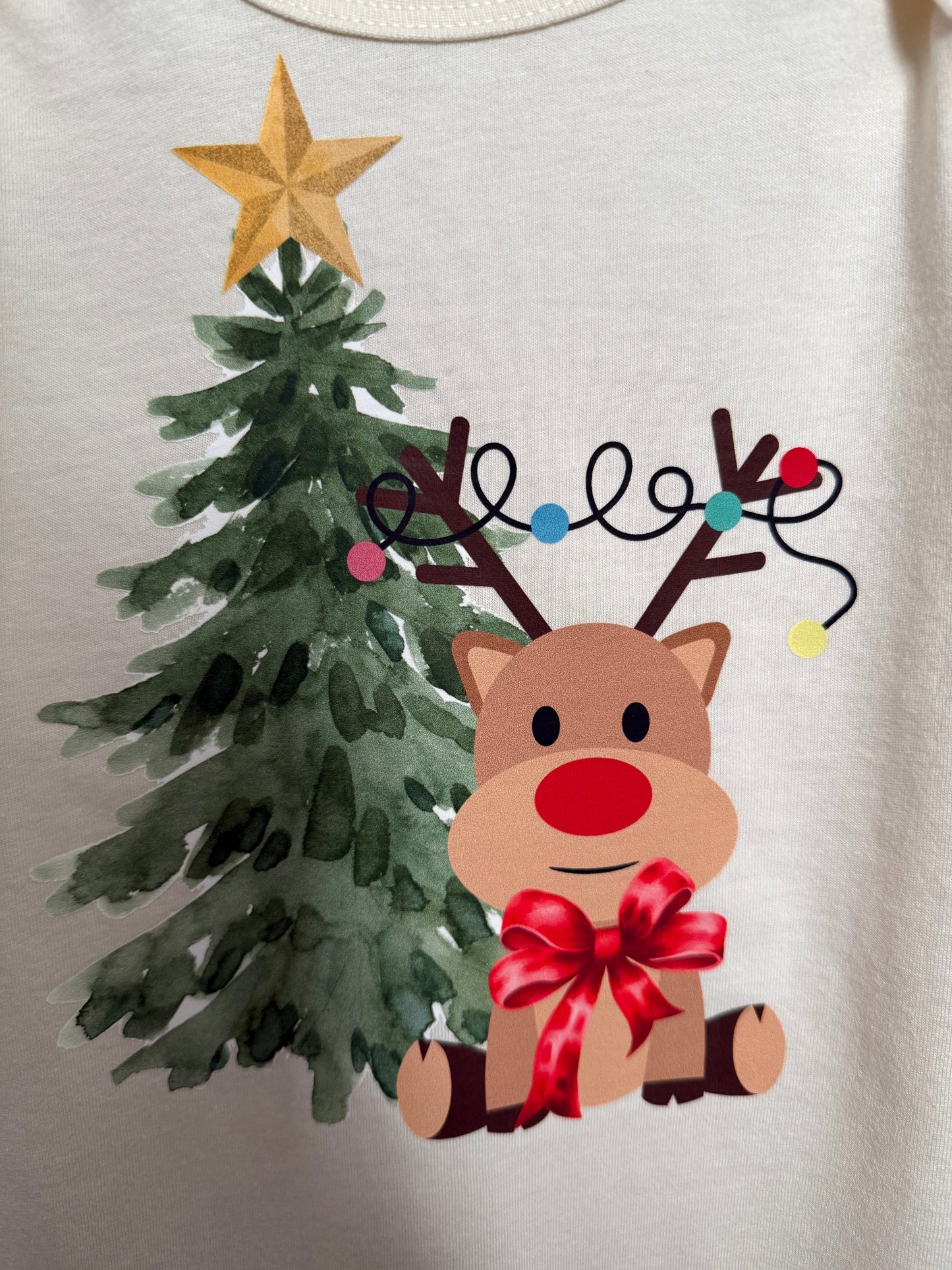 Children's illustration of a reindeer with a red bow and Christmas lights on a cream background