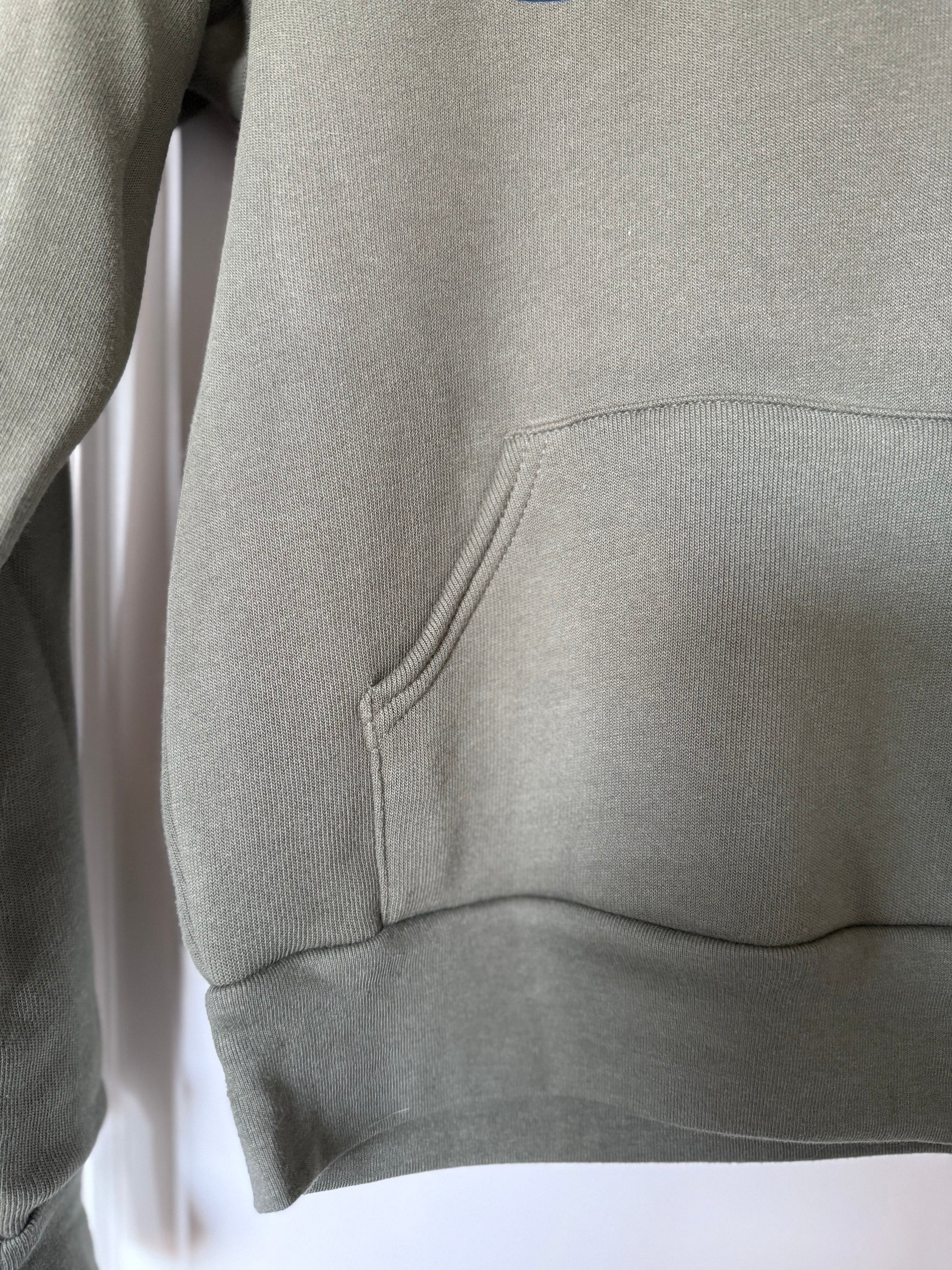 Green hoodie with a pocket on a white background