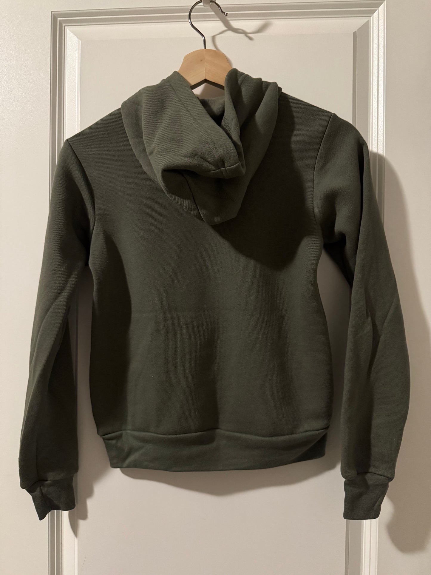 Dark green jacket on a hanger against a white background