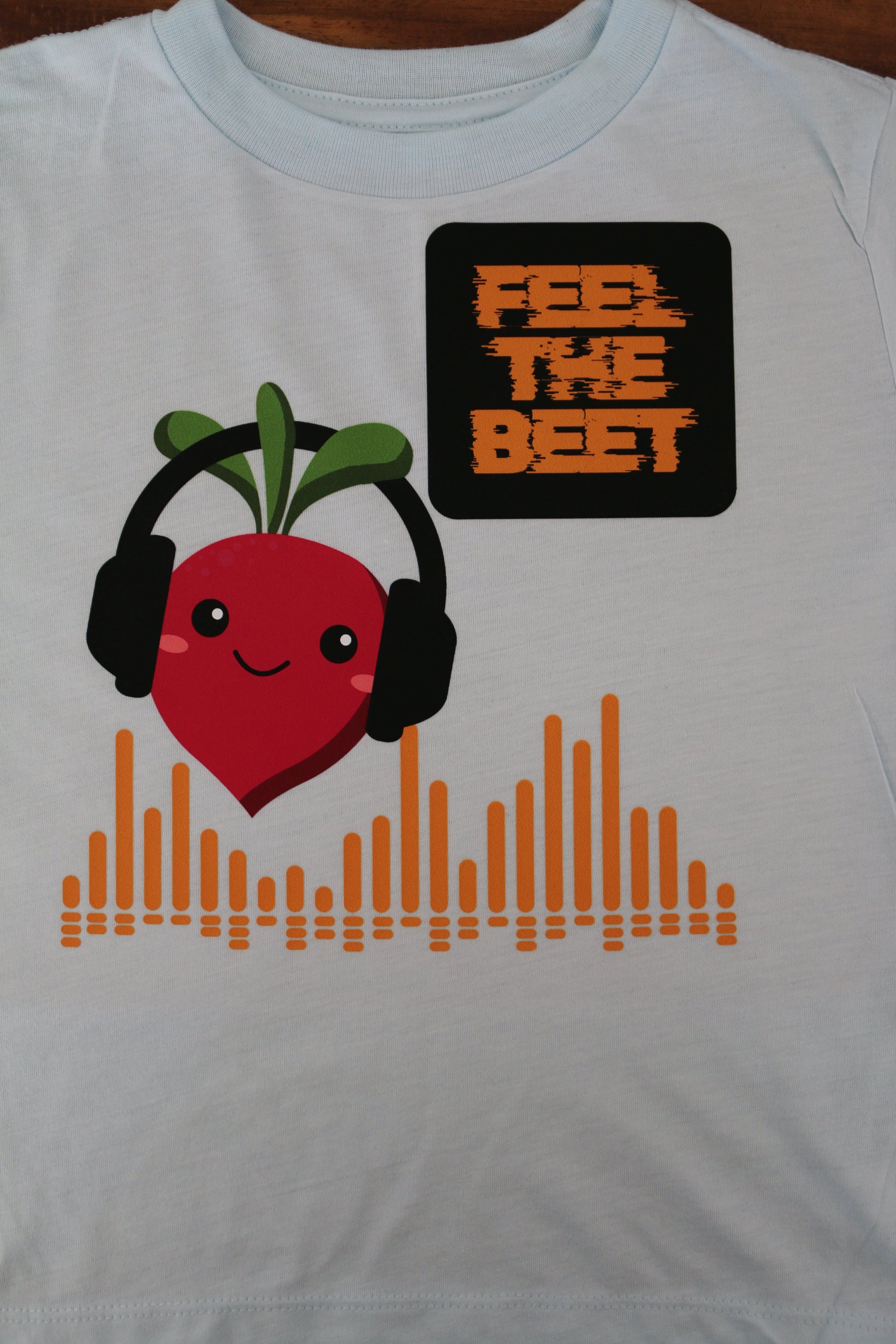 White t-shirt with a red apple character and text on a white background