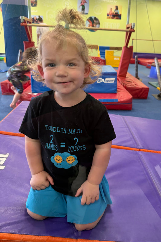 Child in a gymnasium with colorful equipment in the background